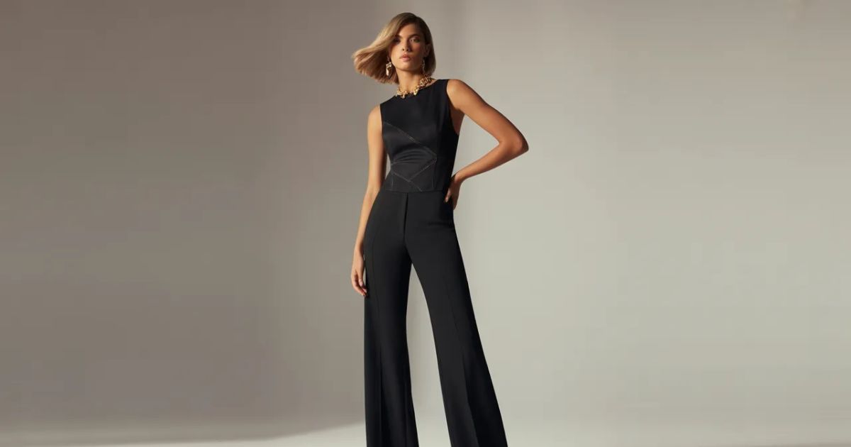 Side profile of a woman in a black jumpsuit highlighting the structured fit and cropped hem.