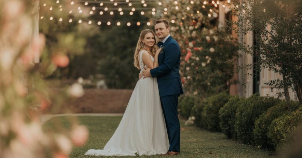 Zoé Chrissos Colton Orr Wedding and Colton Orr exchange vows under a floral arch during their wedding ceremony.